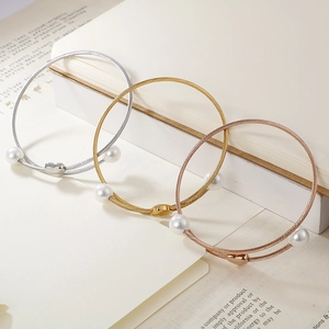 Three elegant titanium steel bangle bracelets with pearls and heart charms in gold and silver