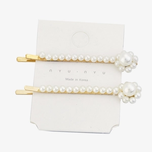 Detail view of pearl flower hair clips on a white card with golden metal finish