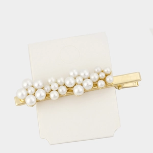 Detailed view of artificial pearls and sparkling rhinestones on golden metal hair clips