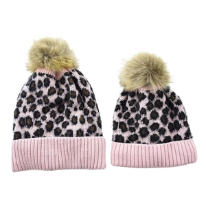 Close-up of pink leopard print knit beanie set with fluffy faux fur pom poms
