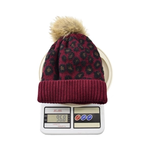 Weighing scale display showing the leopard print burgundy knit hat with pom-pom at 96.8g