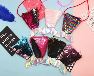 Flat lay of seven colorful mermaid tail sequin purses with reversible glitter finish