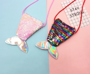 Flat lay of pink and rainbow mermaid tail sequin coin purses with silver fins for girls