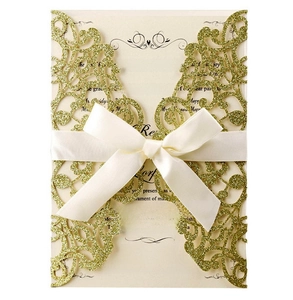 Detailed laser-cut gold glitter wedding invitation with elegant white satin ribbon bow