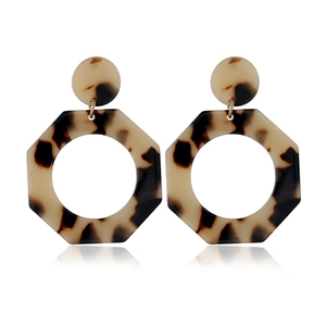 Macro detail of tortoiseshell acetate hoop earrings with elegant geometric octagon pendants