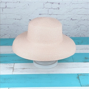 Elegant wide brim straw sun hat in soft pink with a minimalist woven spiral texture