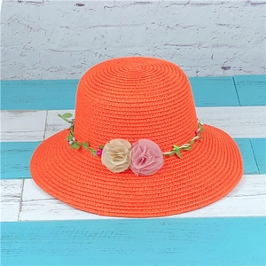 Orange woven straw sun hat with floral vine decoration for beach summer holidays