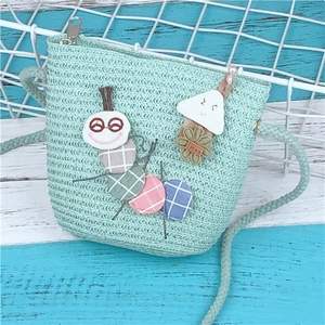 Cute mint green woven straw crossbody bag for kids featuring a cartoon caterpillar design