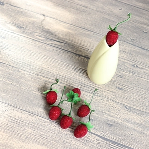 Realistic artificial red berry sprigs with green leaves in a ceramic vase for decor