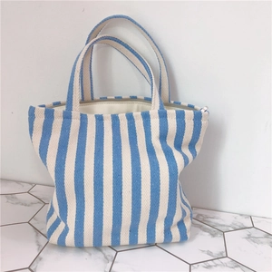 Detail of blue striped canvas tote bag showing the zipper closure and thick fabric texture