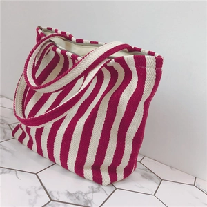 Close-up of red and white striped thick canvas tote bag with zipper and wide handles