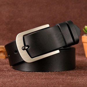 Detail of black leather belt with brushed silver pin buckle on rustic background