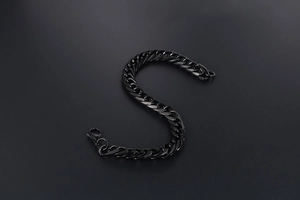 Detail of a minimalist black metal chain bracelet with a secure lobster clasp closure