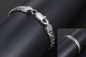 Close-up of silver Cuban link chain bracelet with lobster clasp for men on dark background
