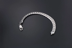 Detailed shot of a polished silver Cuban link bracelet with a strong lobster clasp
