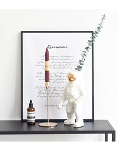 Detalle de un jarrón astronauta de cerámica blanca con visor dorado y candelabro set