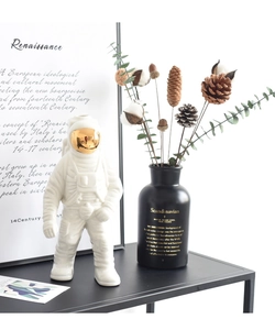 Detalle de jarrón astronauta de cerámica blanca con visera dorada y acabado mate