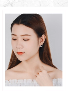 Close-up of dragonfly stud earring with sparkling zircons on a model's ear