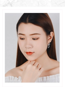 Close-up of model wearing silver moon and star stud earrings with rhinestone accents