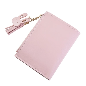 Close-up of pink leather wallet with detailed stitching, gold zipper, and rabbit tassel charm