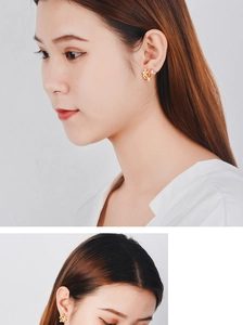 Macro detail of elegant floral earrings with purple petals and a central pearl accent