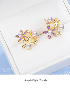 Detailed macro view of triple flower stud earrings with enamel petals and pearls