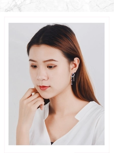 Close-up of elegant moon and star drop earrings with blue cubic zirconia on model