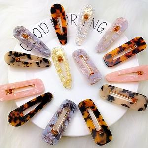 Detail of assorted tortoiseshell and marble acetate hair clips on a white plate