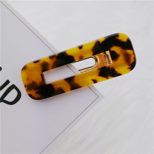 Detailed close-up of a rectangular leopard pattern acetate hair clip with a metal spring