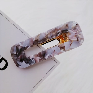 Detail of marble pattern acetate rectangle hair clip with gold metal spring clamp