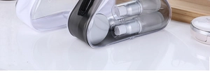 Detailed view of clear PVC toiletry bags with black and white trim on reflective surface