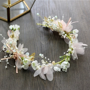 Macro shot of bridal flower crown featuring pink silk flowers and pearl details