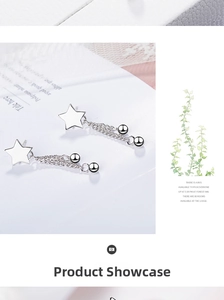 Close-up of silver star tassel earrings with delicate chain and bead charms
