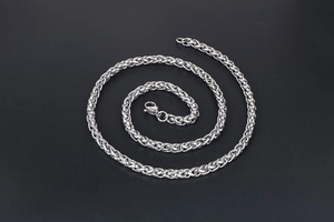 Detailed view of silver stainless steel dragon bone chain with woven texture on black