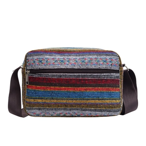 Ethnic style striped canvas crossbody bag with colorful woven patterns and black strap