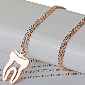 Collier pendentif dent creuse en or rose poli sur une chaîne délicate en acier inoxydable
