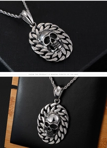 Close-up of vintage titanium steel skull pendant with chain on a textured black display
