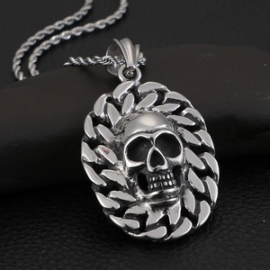 Silver stainless steel skull pendant necklace with link chain on textured background