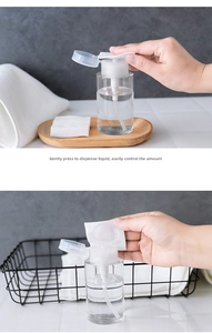 Clear press-down dispenser bottle shown with a cotton pad for makeup remover and toner