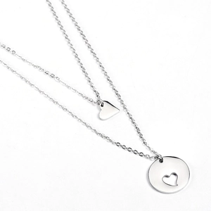 Close-up of silver double-layer necklace with solid heart and cutout circle pendant
