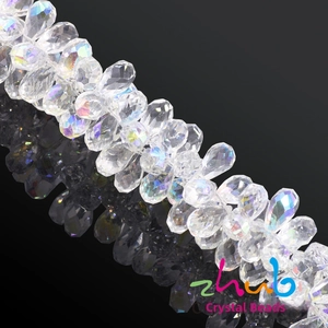 Macro shot of faceted teardrop crystal beads with AB rainbow coating on mirror background