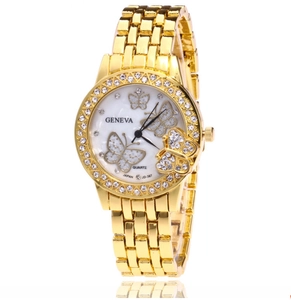 Detailed view of the gold quartz watch dial with shell pattern and butterfly motifs