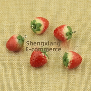 Detailed view of 5 mini 3D resin strawberry pendants with metal rings for DIY crafting