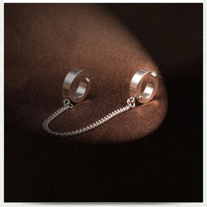 Macro shot of silver titanium steel ear clips with a delicate metal link chain