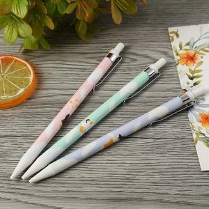 Three colorful pastel mechanical pencils with cloud patterns on a rustic wooden desk