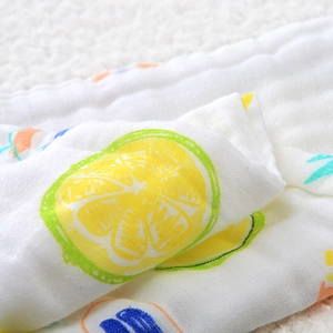 Detail of soft 6-layer cotton gauze baby towel featuring vibrant yellow lemon prints