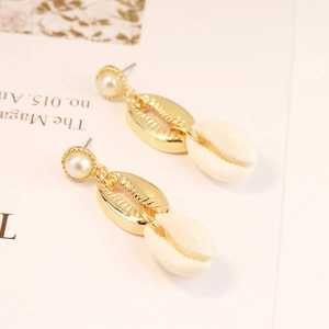 Detail of Bohemian shell earrings with gold metal accents and small pearls