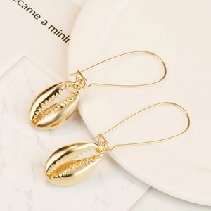 Detail of golden seashell hoop earrings with polished cowrie shell charm and long hooks