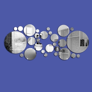 Detail of round mirror wall stickers showing clear reflection on a blue wall surface