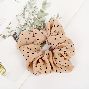 Detailed close-up of beige polka dot scrunchie fabric texture and chiffon material
